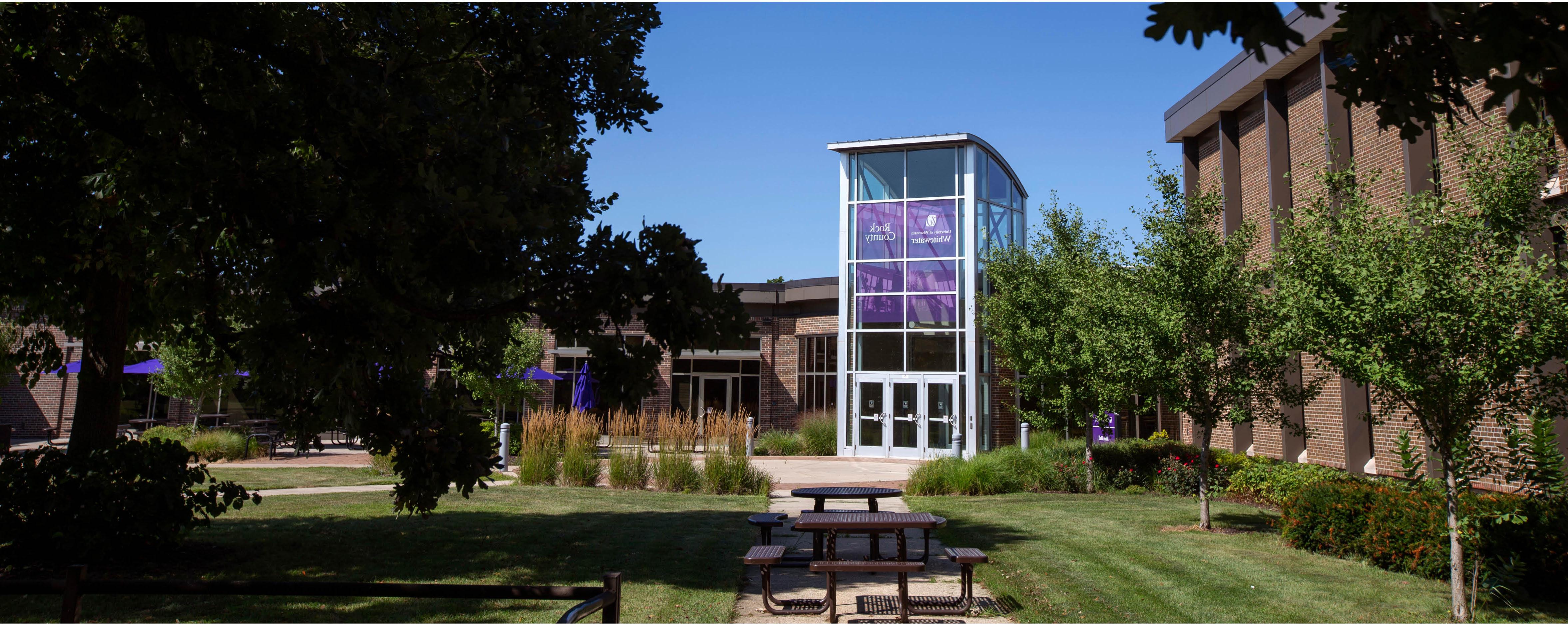 A courtyard leads to Rock County's main building with a purple banner on the windows that says 足彩平台 Rock County.