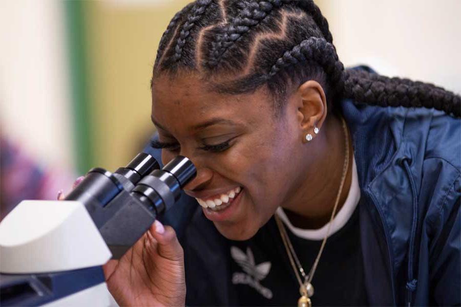 A student looking through a microscope