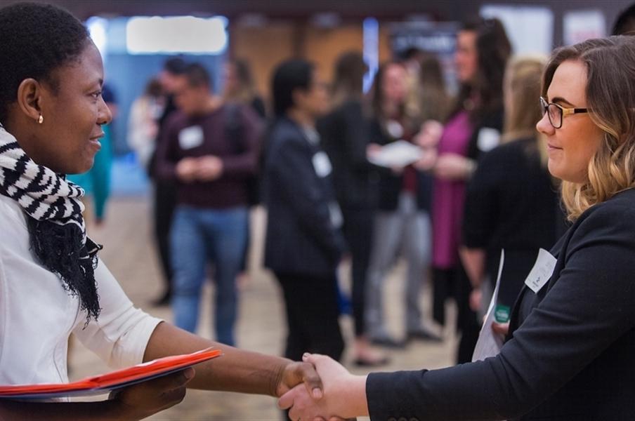 Two people shaking hands at the Hawk Career Fair.